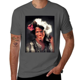 Un t-shirt unisexe, disponible en plusieurs couleurs. Sur la poitrine, une grande image rectangulaire en couleurs représente une personne souriant face à l’objectif. Cette personne porte un maquillage vif, un accessoire fleuri dans les cheveux et une tenue à motifs. L’arrière-plan est sombre, ce qui met en valeur le visage lumineux. Le portrait est encadré dans un rectangle noir. Le nom « Marsha P. Johnson » apparaît imprimé sous l’image selon le modèle du t-shirt présenté.
