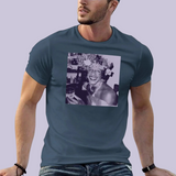 Portrait carré imprimé sur un t-shirt. L’image montre une personne souriante dans un environnement intérieur, tenant un verre à la main. Elle porte une coiffure ornée de nombreuses fleurs et des bijoux visibles autour du cou. L’ambiance évoque une scène festive. Le portrait est présenté dans une teinte violette sur fond clair.