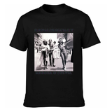 T-shirt noir avec photo de trois personnes marchant en ville et textes “Revolutionary” et “Marsha & Sylvia”.