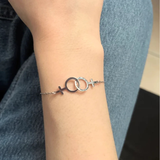 Bracelet lesbien double Vénus argenté porté au poignet, bijou féminin et symbolique