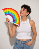 Éventail Pride arc-en-ciel tenu à la main par une femme souriante
