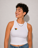 Pin’s cœur Pride multicolore fixé sur un t-shirt blanc