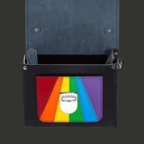 Vue du sac ouvert avec le rabat relevé. L’intérieur sombre et structuré est visible. Le drapeau Pride apparaît sur la poche extérieure. Les fixations internes et la rigidité du cuir sont mises en avant.