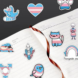Photo montrant des stickers trans collés sur un carnet ouvert, illustrant leur usage décoratif sur des objets du quotidien.