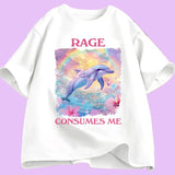  T-shirt unisexe décliné en plusieurs couleurs. Sur le devant, une grande illustration centrale : un dauphin bleu-violet sautant hors de l’eau. Derrière lui, un arc de couleurs et un ciel jaune et violet. Autour, fleurs roses et petits cœurs colorés. Au-dessus : le mot “RAGE” en lettres majuscules rose foncé. En dessous : “CONSUMES ME” dans la même typographie. Le visuel occupe une zone rectangulaire centrée sur le torse. 