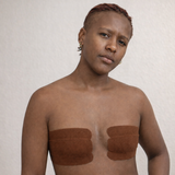 Personne transmasculine de couleur de peau foncée qui porte du transtape marron